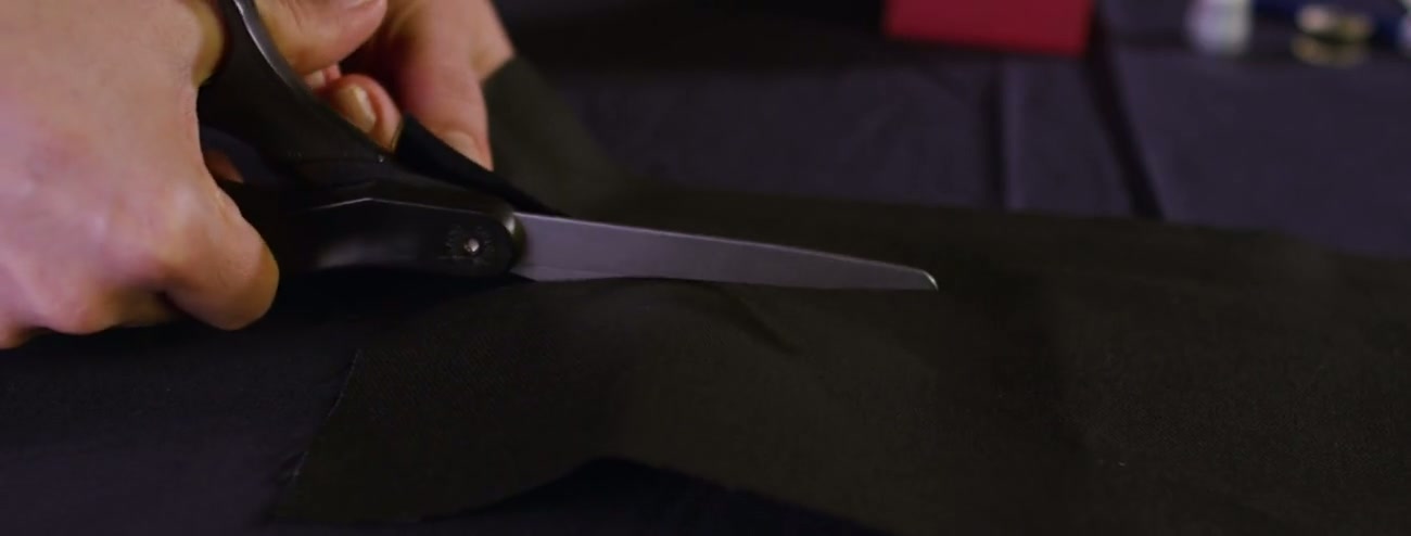 Close-up of fabric being cut with industrial shears on a garment production line