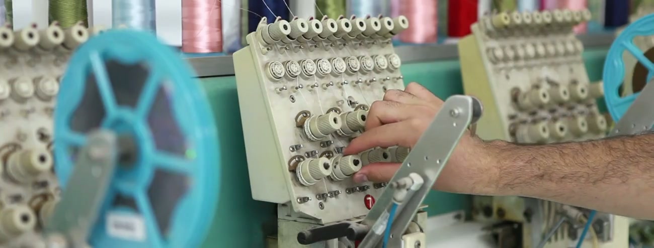 Industrial sewing machines operating on a garment production line